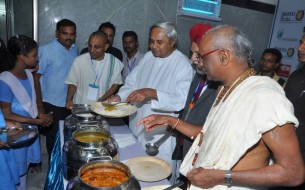 At the end of the inauguration, CM Patnaik and Madhu Pandit Dasa serve a meal to some of the government school students present at the inauguration